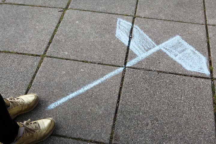 Schuhe, die vor einem Wegweiser stehen