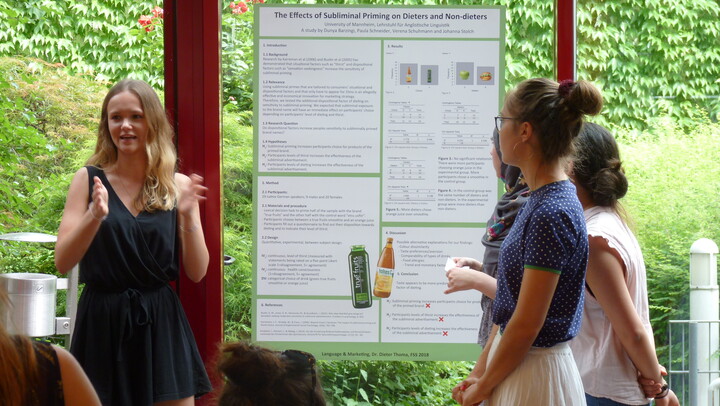 drei Personen beim Erklären eines Posters auf der Posterkonferenz