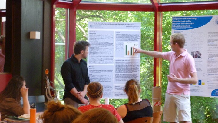 zwei Personen, die ein Poster erklären bei der Posterkonferenz